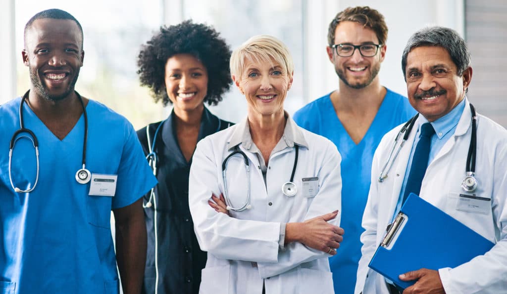 Team or group of a doctor, nurse and medical professional colleagues or coworkers standing in a hospital together.